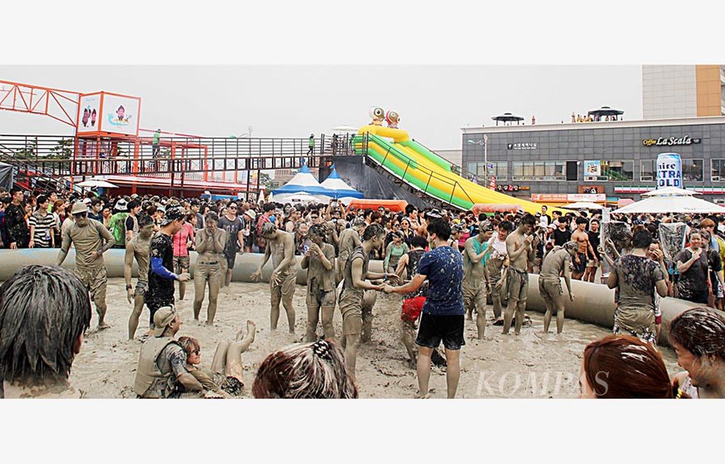 Pengunjung bermain di wahana yang digenangi lumpur dalam Festival Lumpur Boryeong, di Boryeong, Korea Selatan, Sabtu (22/7). Festival itu mampu menggaet wisatawan mancanegara.
