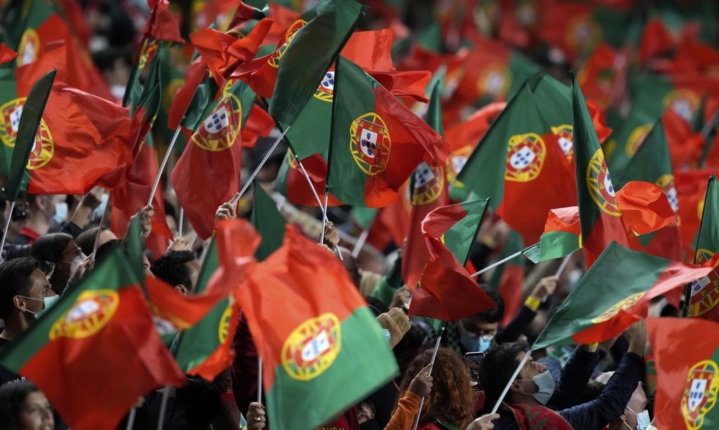Pendukung Portugal mengibarkan bendera negaranya saat melawan Serbia dalam lanjutan kualifikasi Piala Dunia 2022 zona Eropa grup A di Stadion Luz, Lisabon, Portugal, Senin (15/11/2021) dini hari WIB.