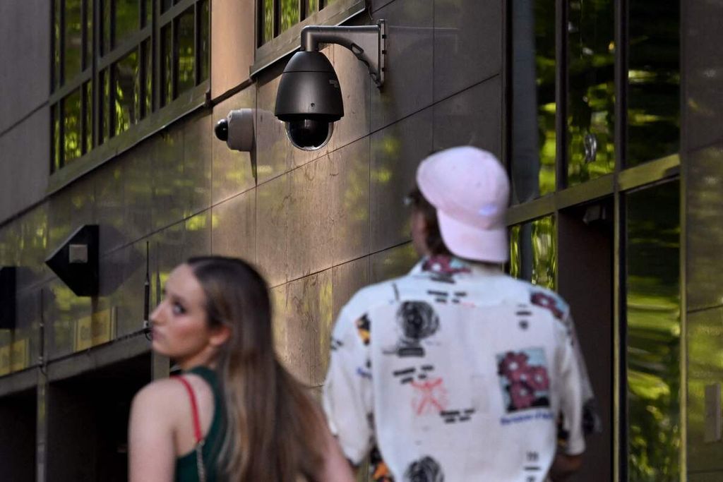 Warga berjalan melewati sebuah kamera pengawas keamanan di Melbourne, Australia, Rabu (9/2/2023). 